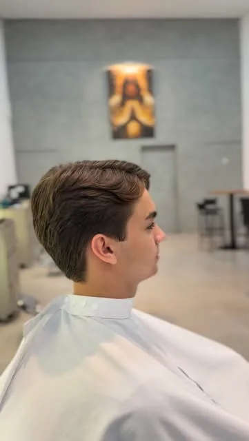 Jovem de perfil com corte social penteado para o lado